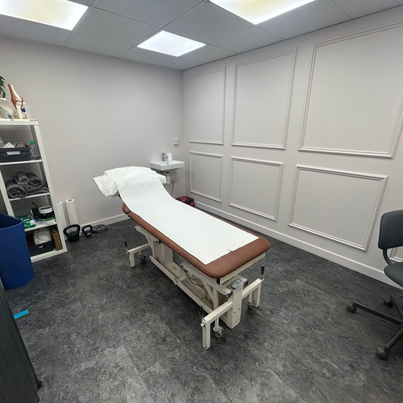 Photo of clinic room A clean, bright treatment room with an examination plinth and sink.
